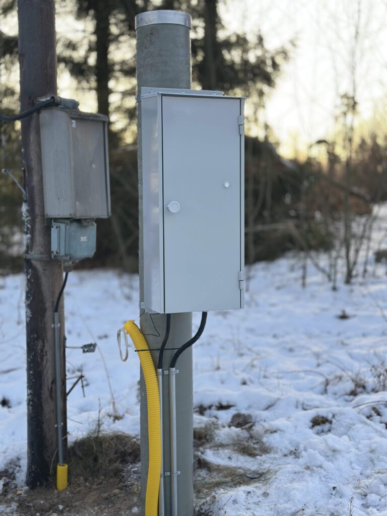 Stängt markmätarskåp monterat på stolpe vintertid i Rimbo kommun